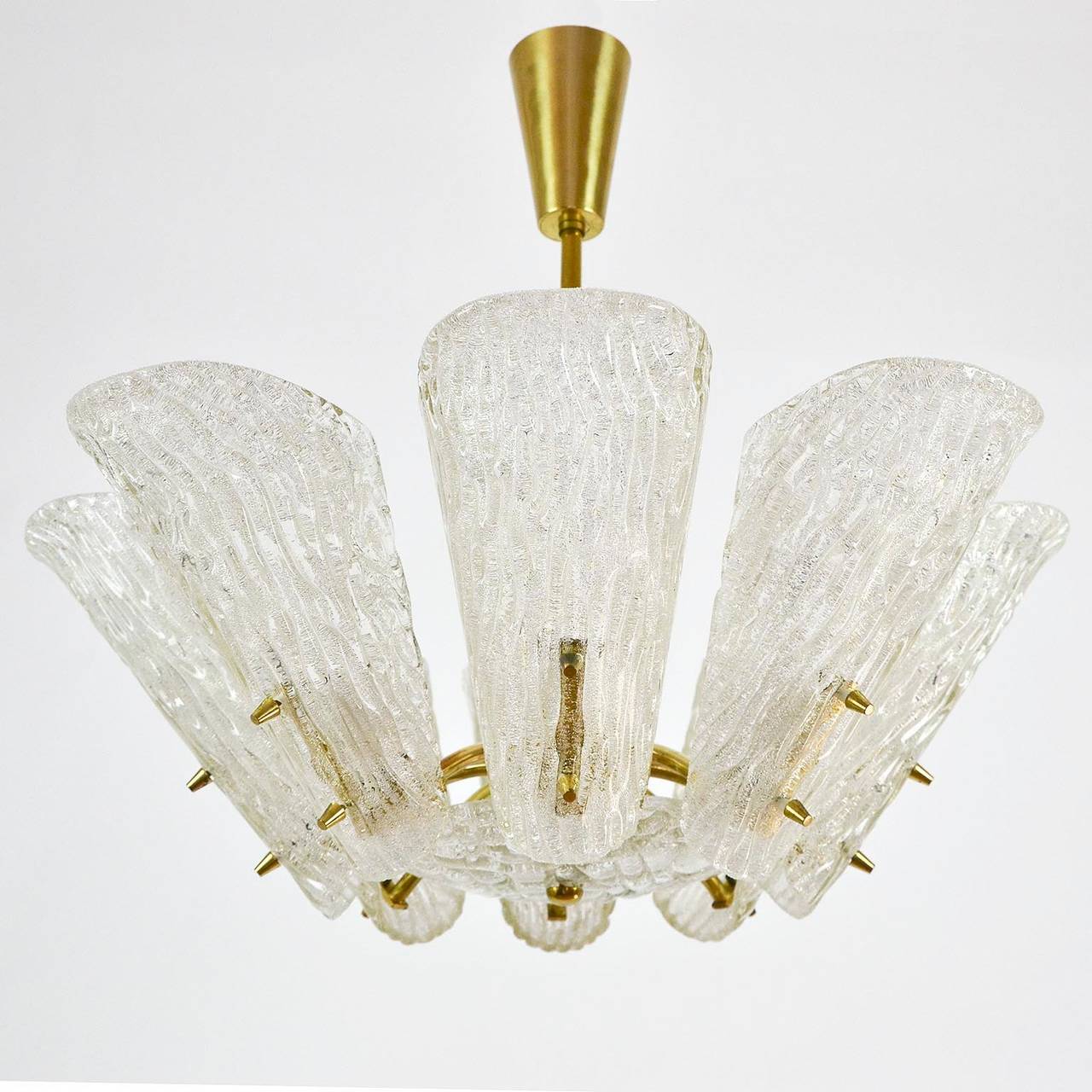 A Viennese glass and brass chandelier by J.T. Kalmar from the 1950s. 
The light features eight arms with sockets for small Edison base E14 bulbs (max. 40W per bulb) or LEDs covered with pressed glass lamp shades.

Diameter: 23.6 in. (60 cm).
Height:
