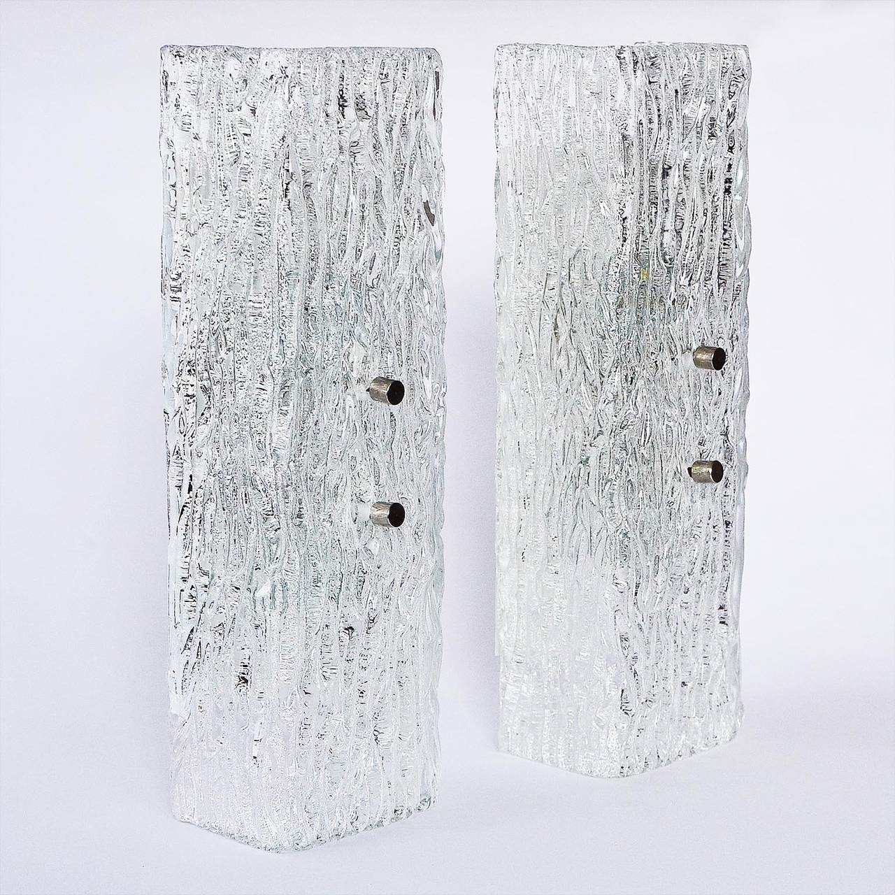 Beautiful pair of 1950s glass sconces or wall lamps by J.T. Kalmar, Vienna, Austria. Thick glass with different textures on the in- and outside creates a fantastic light effect. The chrome bolts can be replaced with brass ones if required.

They