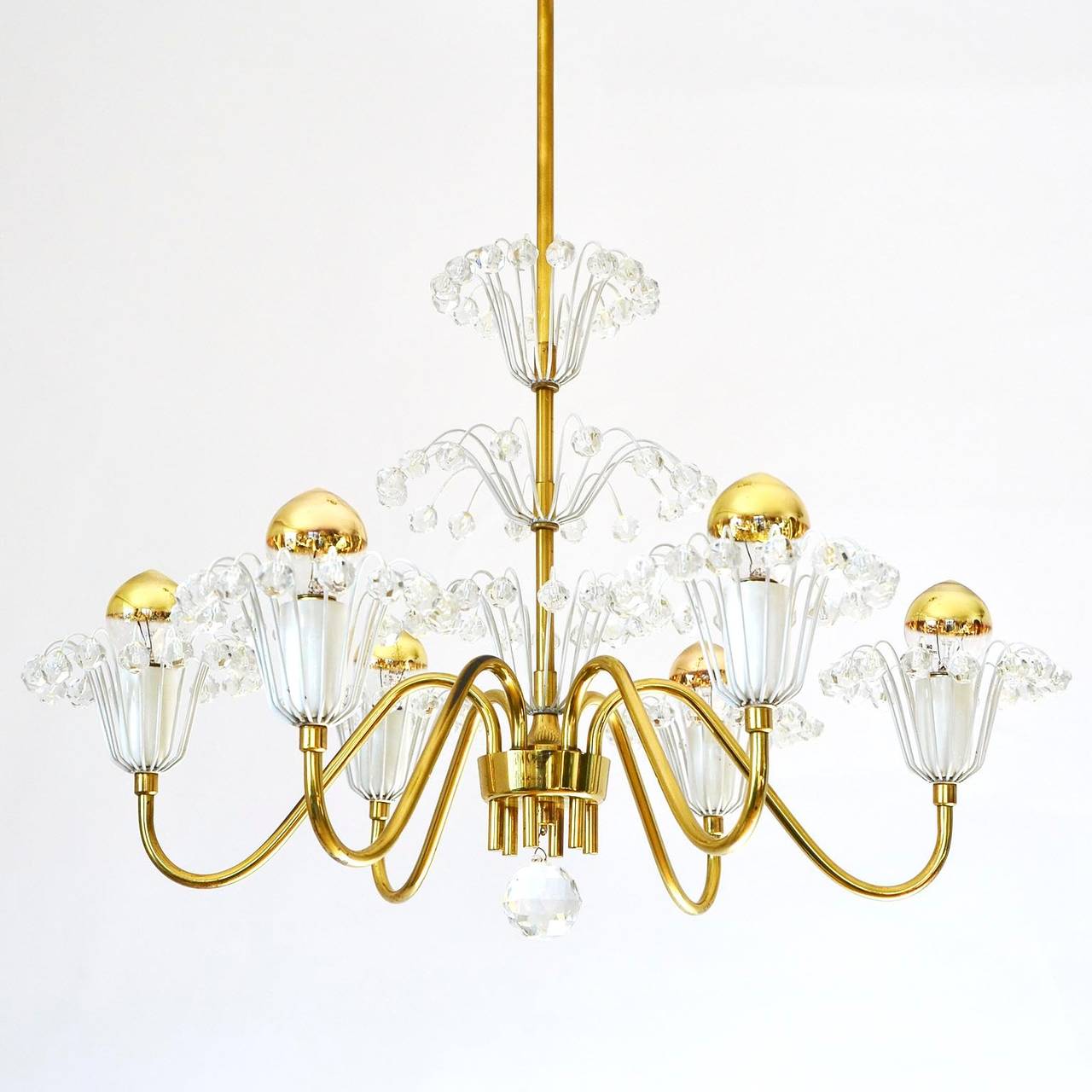 A very nice Viennese chandelier by Emil Stejnar for Rupert Nikoll, Austria, manufactured in midcentury, circa 1950.
It is made of brass, white lacquered metal and hand cut crystal glass. 
The light is in excellent condition. It has six sockets for