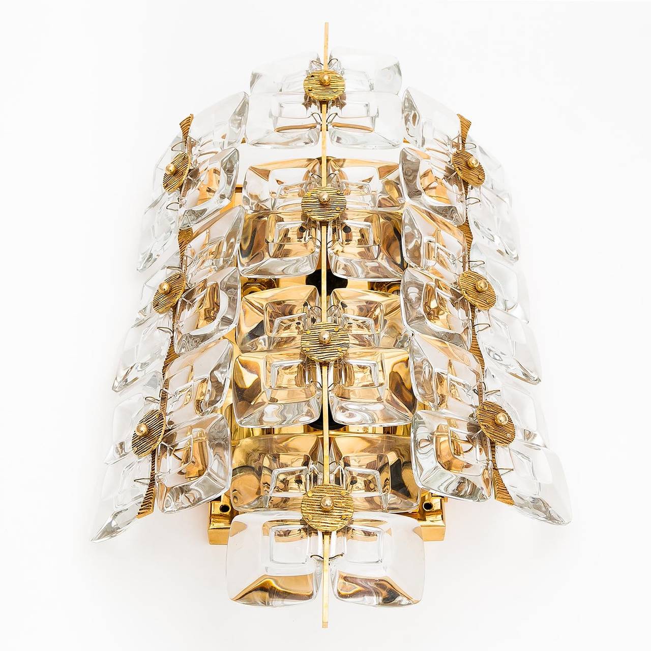 A large, high quality and impressive sconce by Palwa, Germany, manufactured in Mid-Century, cira 1970 (late 1960s or early 1970s).
It is made of a gilded brass frame with square lens glass pieces and gold/bronze elements. 
The lamp has six small