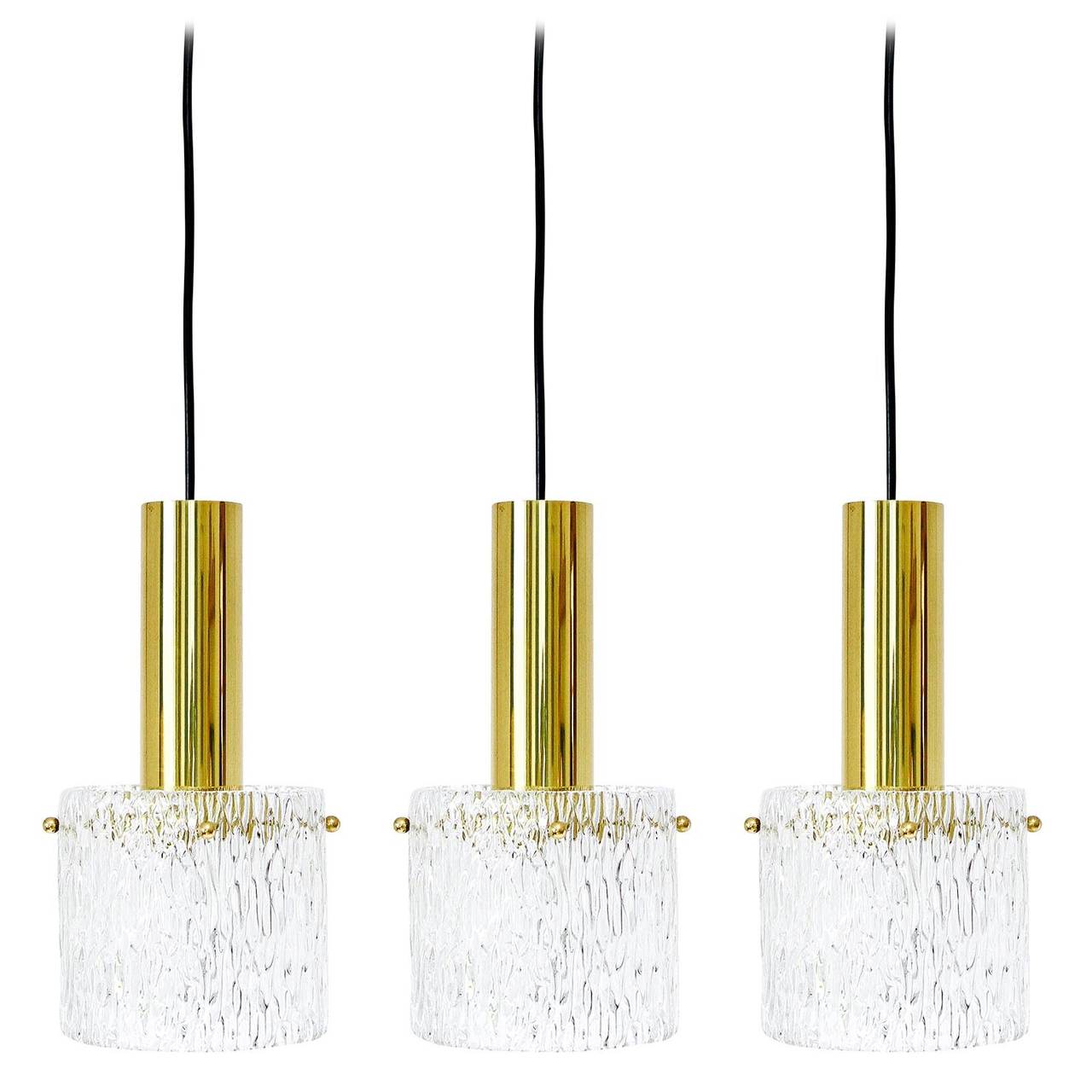 Three textured glass and brass hanging lamps from Kalmar, 1950s. Each light has one socket for a medium base Edison bulb (100 W maximum). The length of the cord can be customized to any length for free. There are also wider and flatter US-canopies