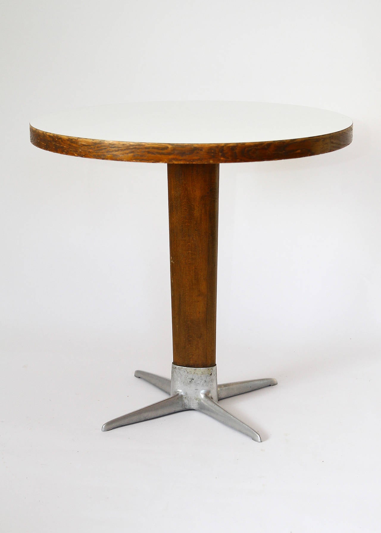 A Viennese coffee table, designed by the Austrian architect Prof. Oswald Haerdtl and produced by Thonet, Austria, 1950's. This is a rare version with a round top and the Haerdtl-specific X-base. It is made of nutwood and the top is laminated with
