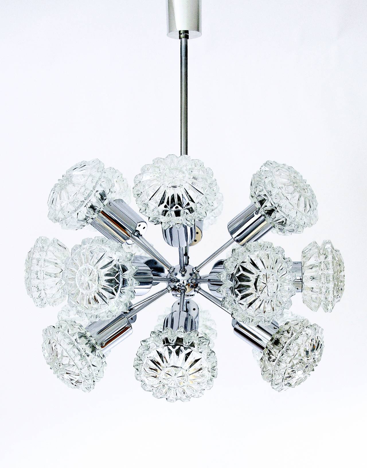 A 18 arm sputnik chandelier with dramatic textured glass covers and a chrome frame, manufactured in Germany in Mid-Century, circa 1970.
The design is attributed to Richard Essig.
The lamp has 18 sockets for small Edison screw base bulbs or LEDs (E14