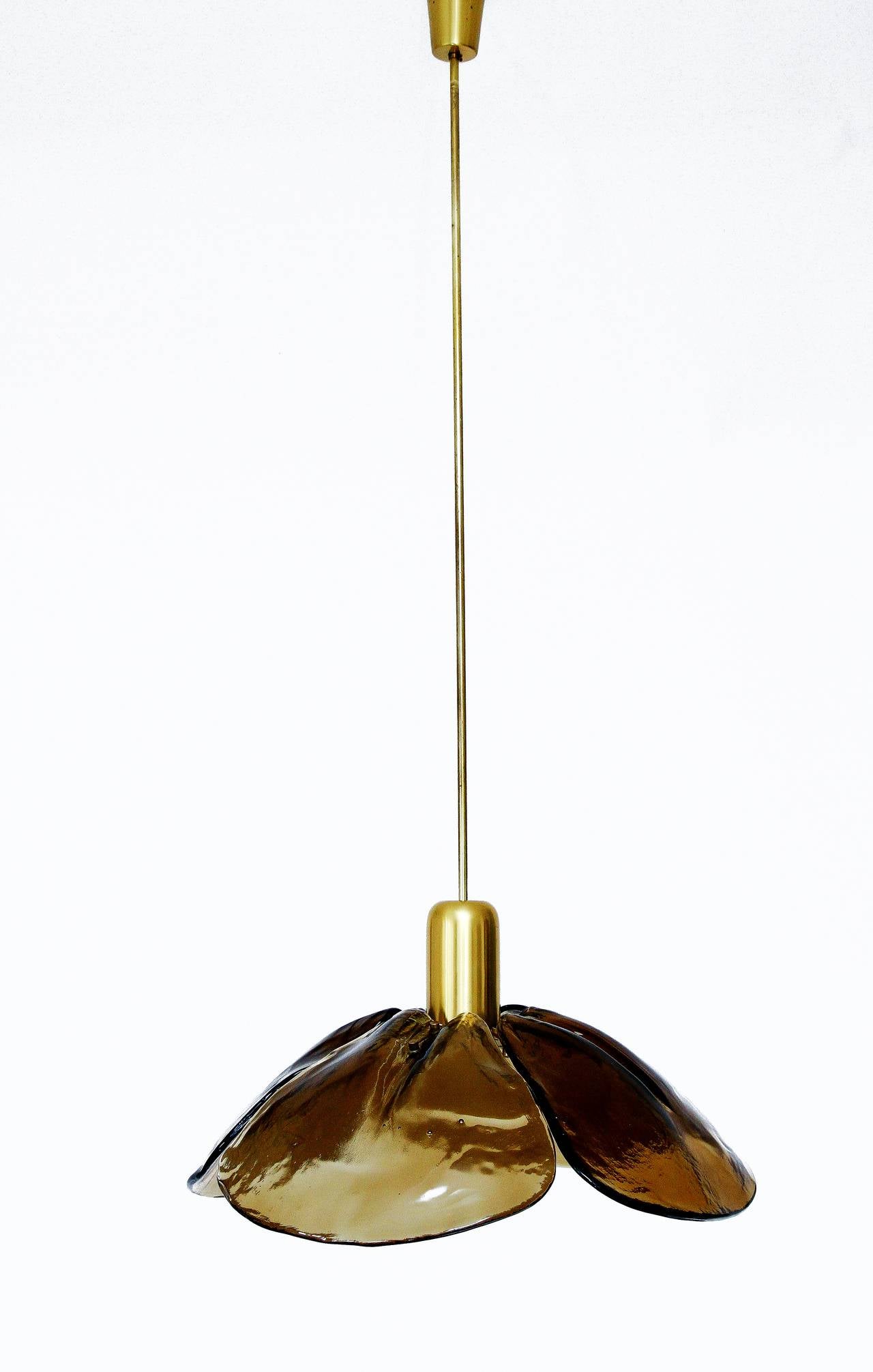 A large pendant light in the form of a flower by Kalmar Franken KG manufactured in midcentury, circa 1970. Four smoke or amber tone Murano glasses are mounted on a brass fixture.
The light has one socket for a standard screw base bulb up to max.
