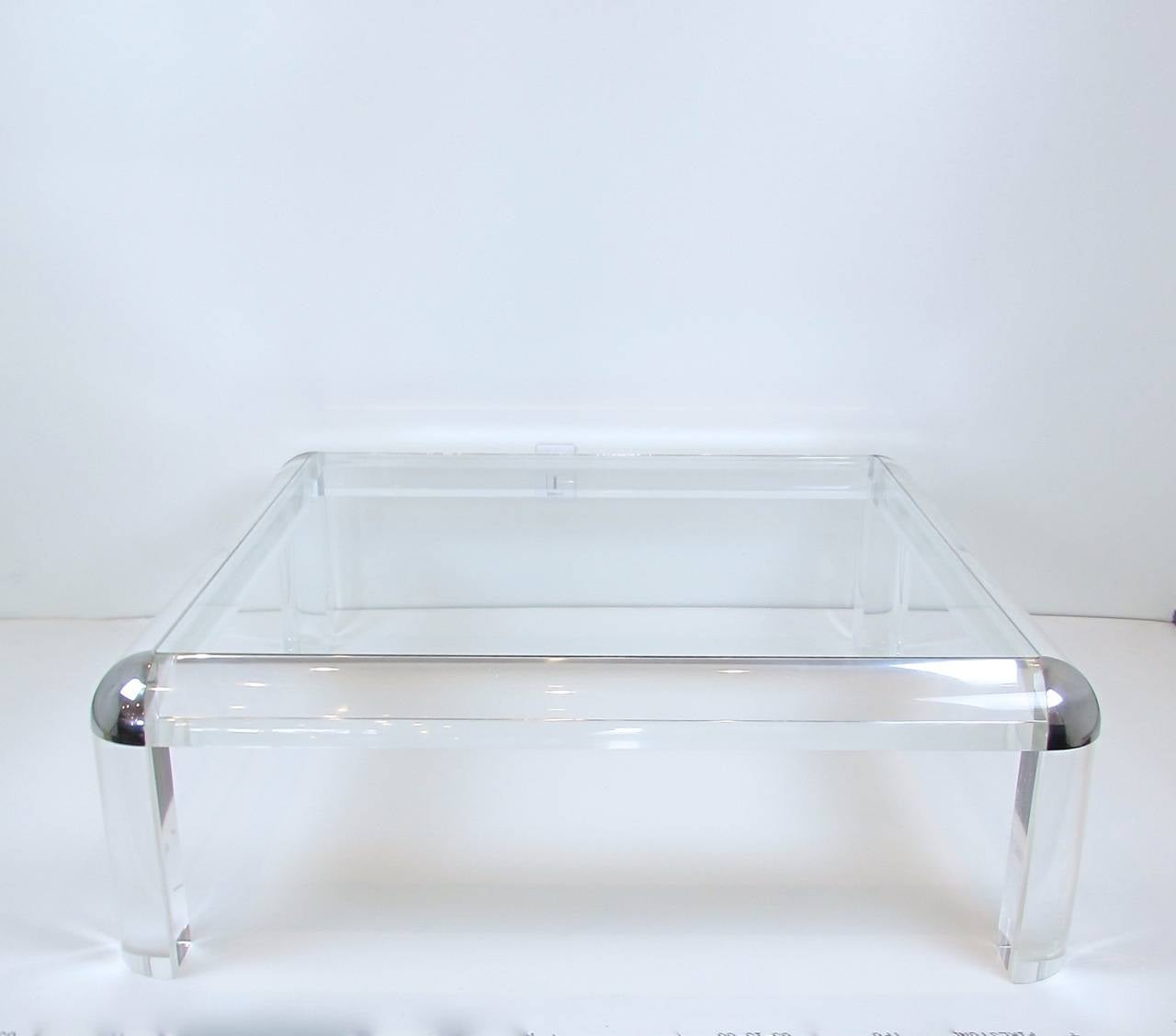 Thick acrylic and chrome coffee table in the style of Karl Springer.  Glass is like new and acrylic has crazing throughout this is consistent with age.