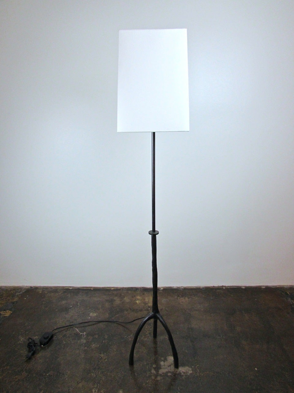 Textured, solid bronze Trepied three footed floor lamp with paper shade by Christian Liaigre.