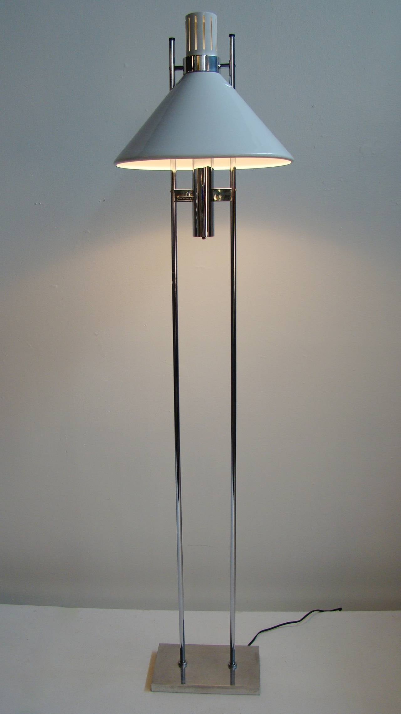 This floor lamp features a white powder coated shade supported by two chrome bars and sits on a chrome base. It retains the original Sonneman paper label.