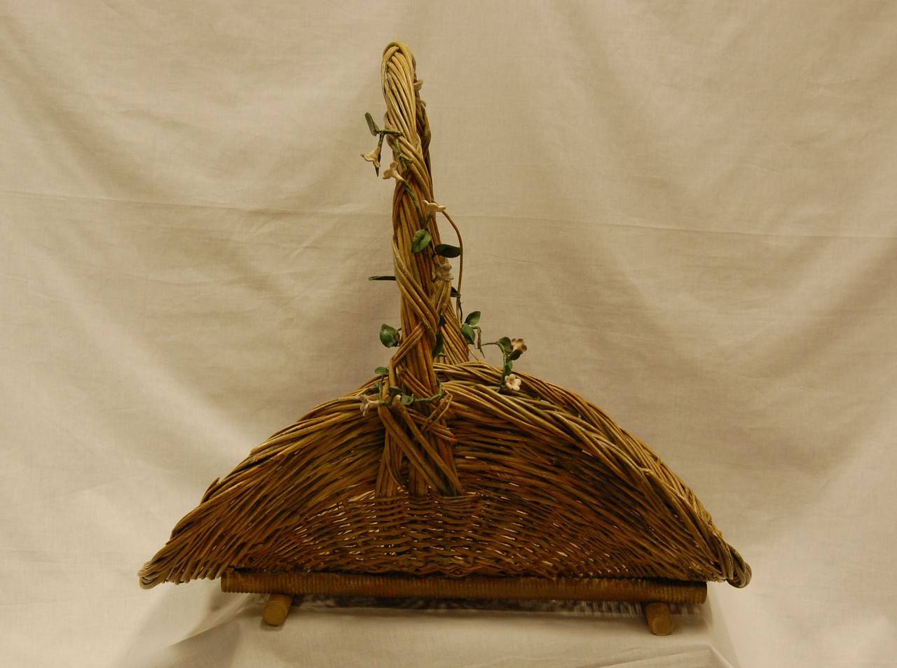 Exceptionally large rattan basket with handle, interwoven with wire, porcelain flowers and leaves. In original finish.