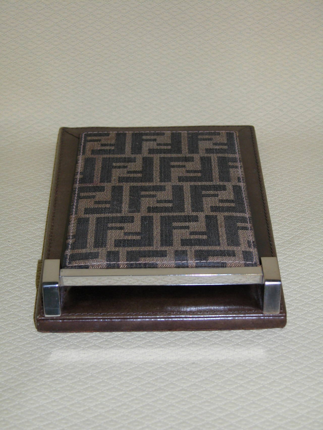 This genuine Fendi brand notepad holder was purchased in the early 70's and has been completely cleaned and has new soft brown leather applied on the underneath. It measures 6
