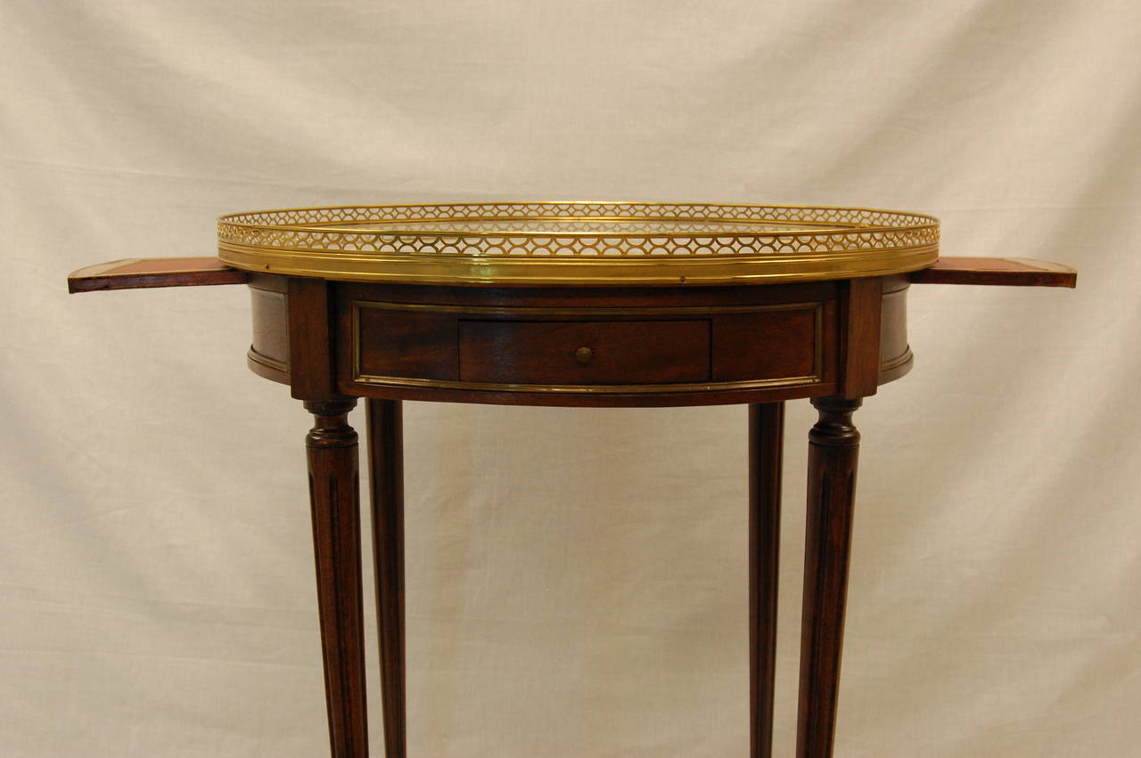 French Louis XVI Style Bouillotte table with marble top and brass gallery, circa 1860 1870. Two drawers and two pull-out trays with leather inserts. Gray and White marble top.