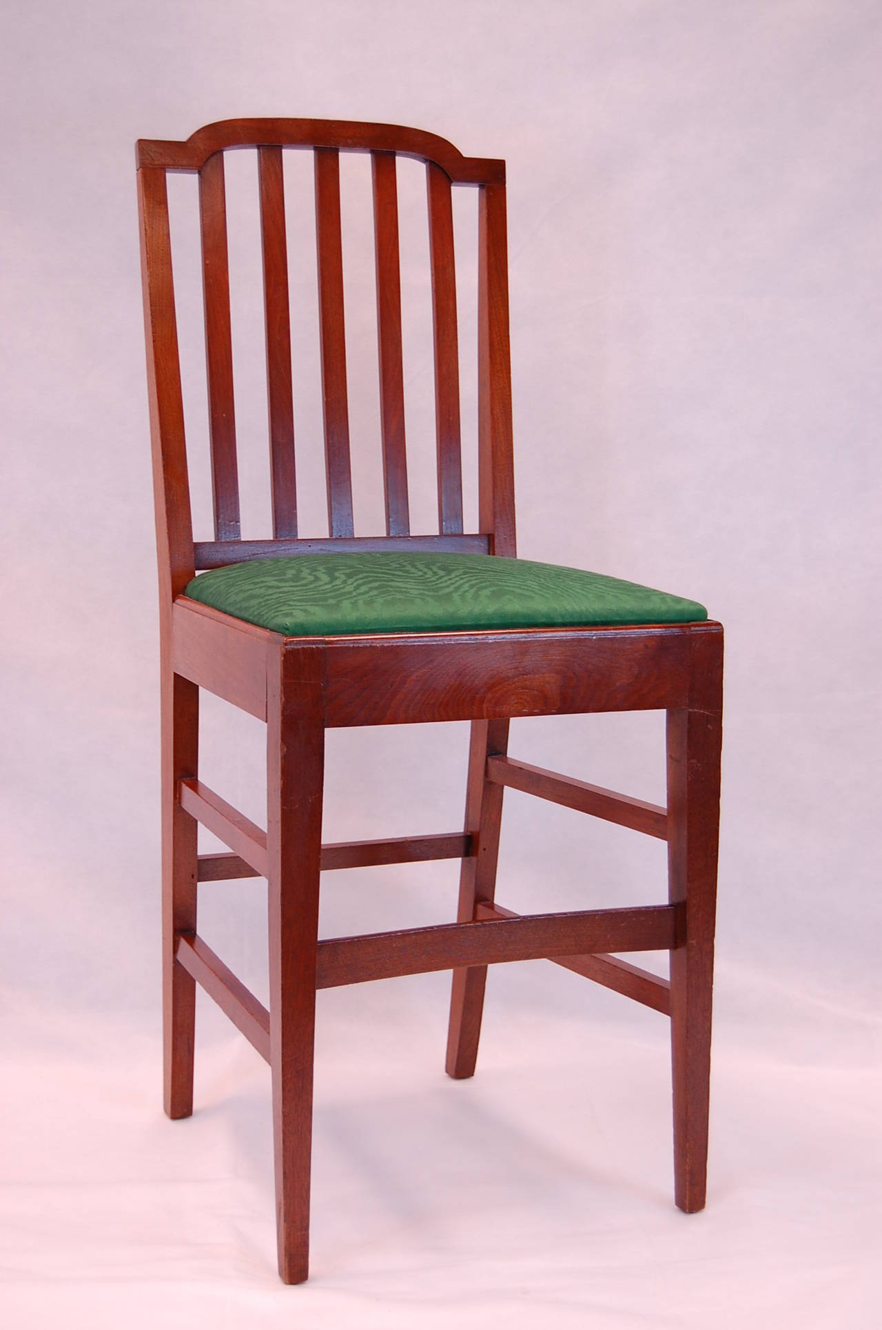 Mahogany bar chair with unusual curved front stretcher. Covered in green Clarence House moire´ cotton fabric.