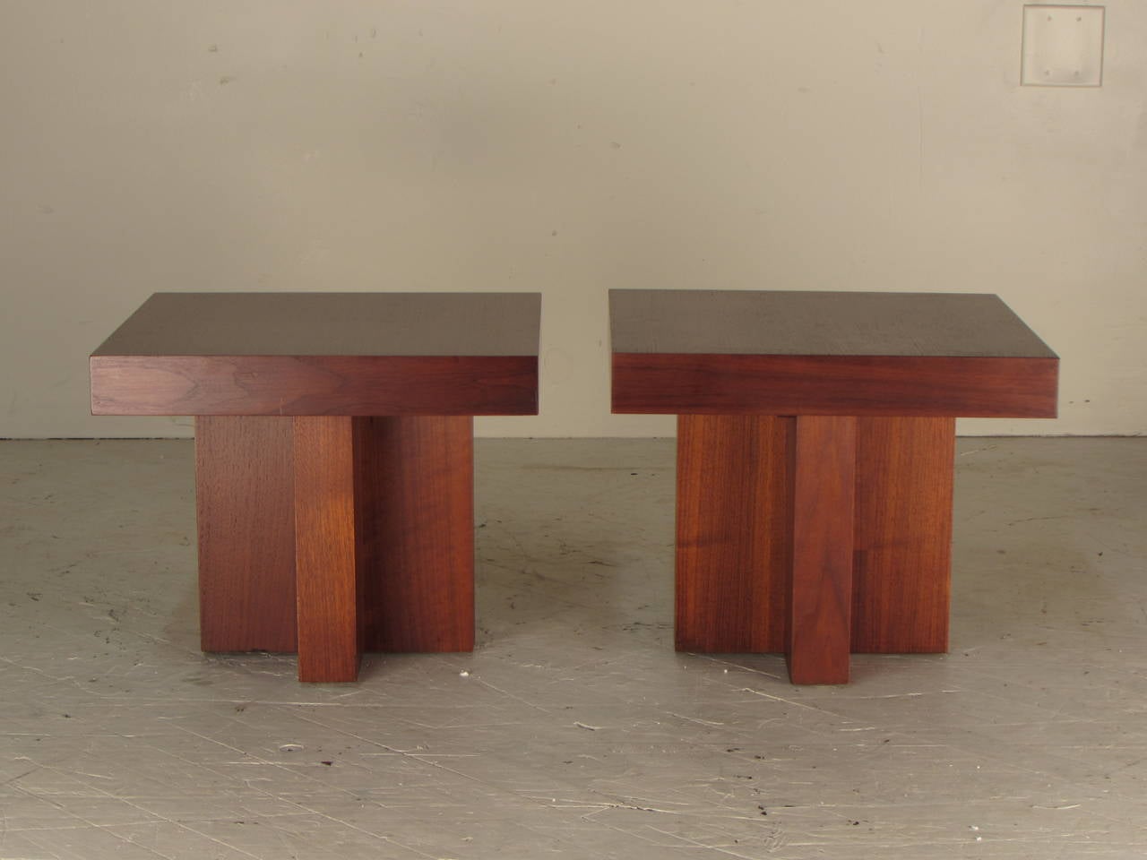 Wonderfully architectural pair of walnut side tables on cruciform bases designed by Milo Baughman for Thayer Coggin. May be used separately or together as a cocktail table. 
These have just been professionally reconditioned and are like new.