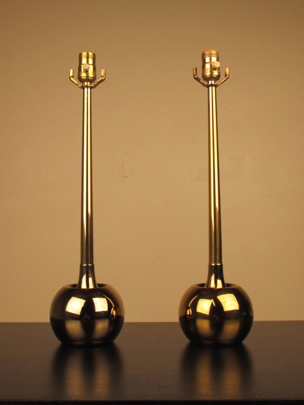 Absolutely devastating pair of mid-century brass orb lamps by Laurel. 
The bases are cast metal which is brass plated--a hallmark of Laurel lamp construction. Designer unknown.

Excellent vintage condition. One lamp has a slightly richer tone
