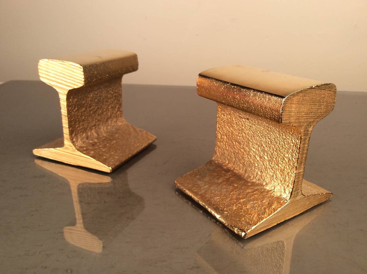Industrial meets glam! MidCentury cast metal railroad tie bookends plated in 24 karat gold. Stunning look, heavy construction and in mint, unused condition (were still packed in original box when found).