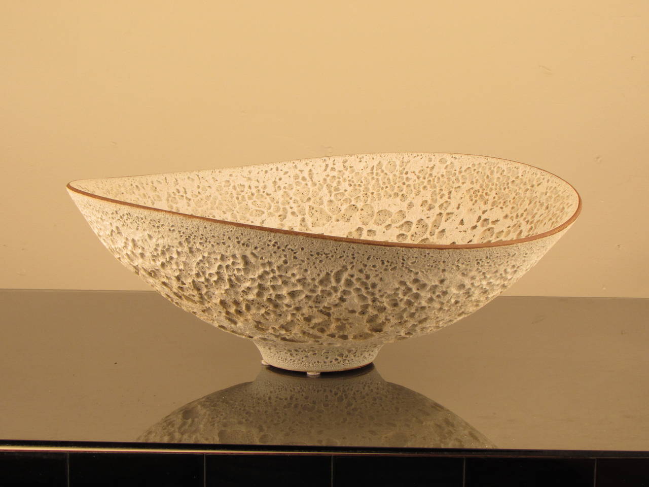 Jaw-dropping footed bowl by working studio potter, Jeremy Briddell (b.1971). This piece features a matte white crater or volcanic glaze evocative of Gertrud + Otto Natzler. Incredibly well-thrown and beautifully balanced; Briddell is a potter who