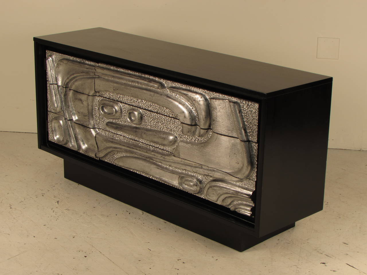 Striking sideboard with ebonized cabinet and sculptural relief front panels with silver leaf. This piece has been completely restored and is in excellent condition.