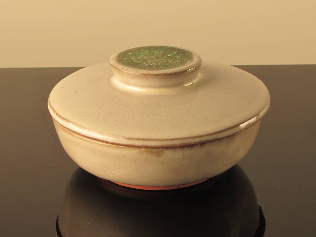 Lovely lidded vessel by Design Technics. Designer unknown. Simple white glaze showcases the stunning green crystalline glaze pool on top of the finial--a truly beautiful pot! Incised Design Technics mark underneath.