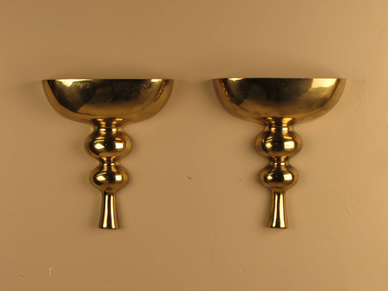 Stunning pair of cast brass wall mount candelabra or candle holders by Tony Paul. Each piece holds 3 standard taper candles.