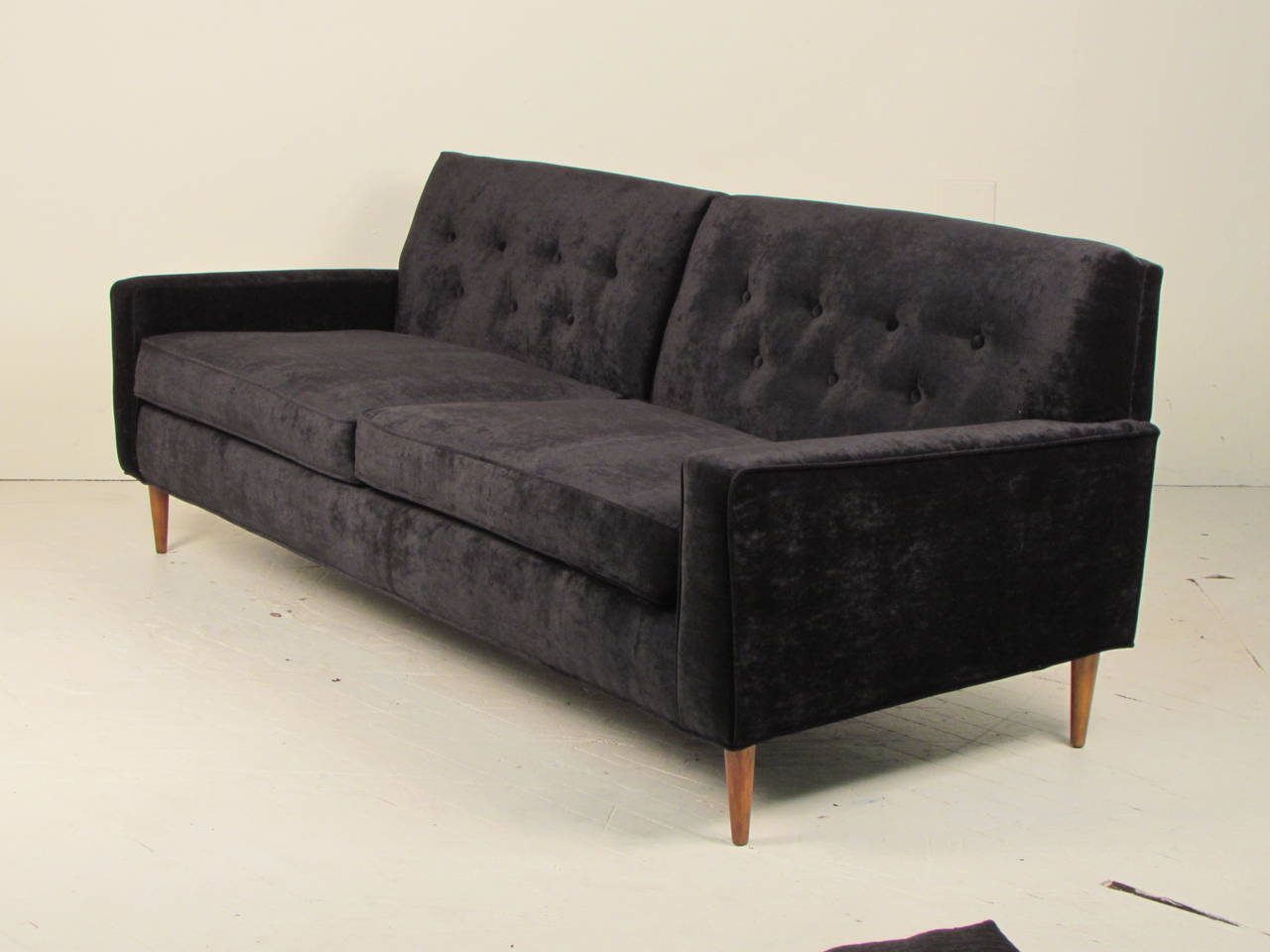 Glamorous black velvet sofa in the style of Milo Baughman. This piece has been completely restored and reupholstered in a fantastic upholstery velvet. Beautiful button detail on back cushions. Very comfortable and excellent quality. This is a 75
