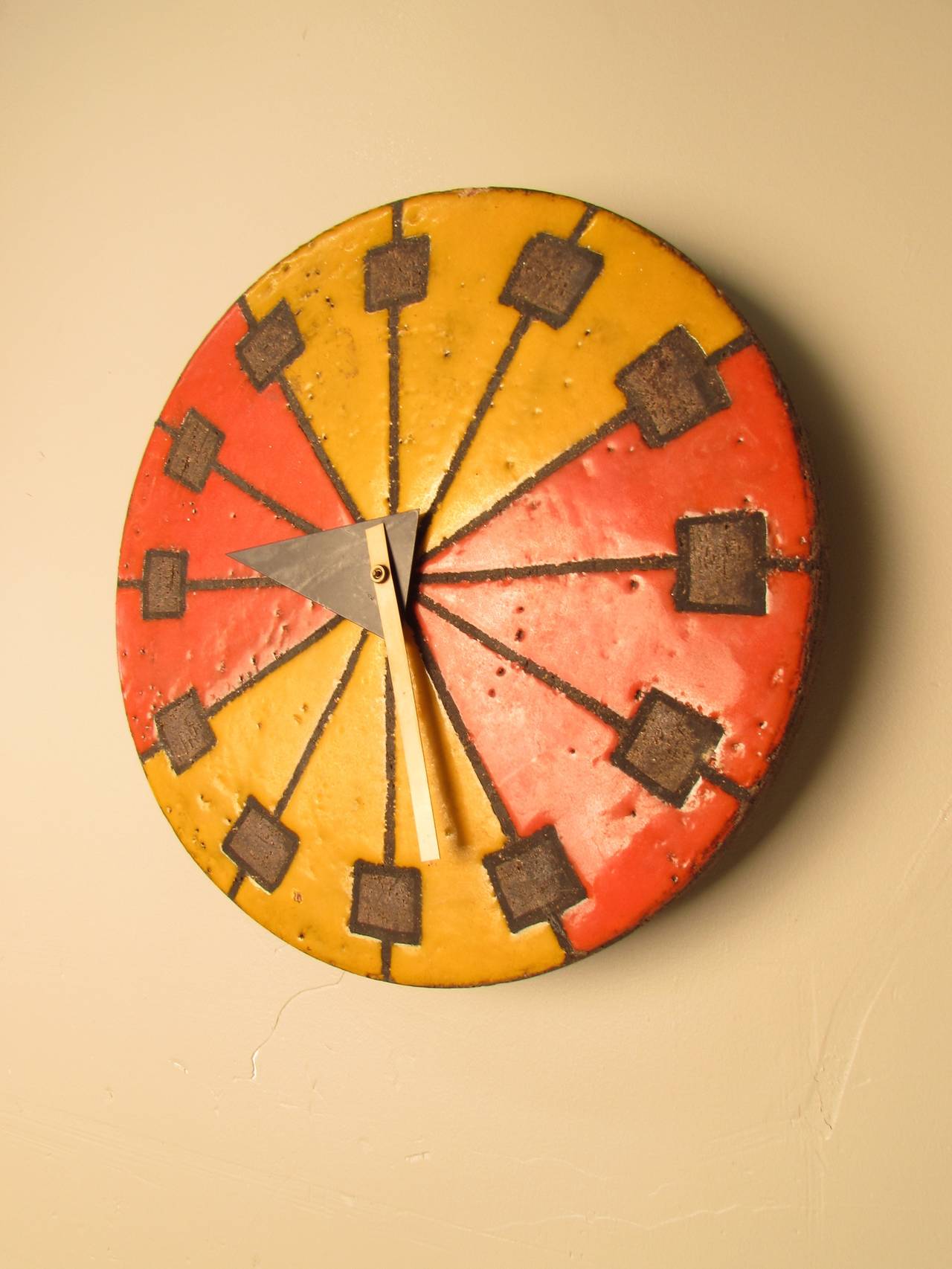 Iconic piece of midcentury design--ceramic clock produced for the Howard Miller Clock Company. Hands were designed by George Nelson and face was  designed and crafted by Aldo Londi, an Italian designer most known for his pottery lamps and decorative