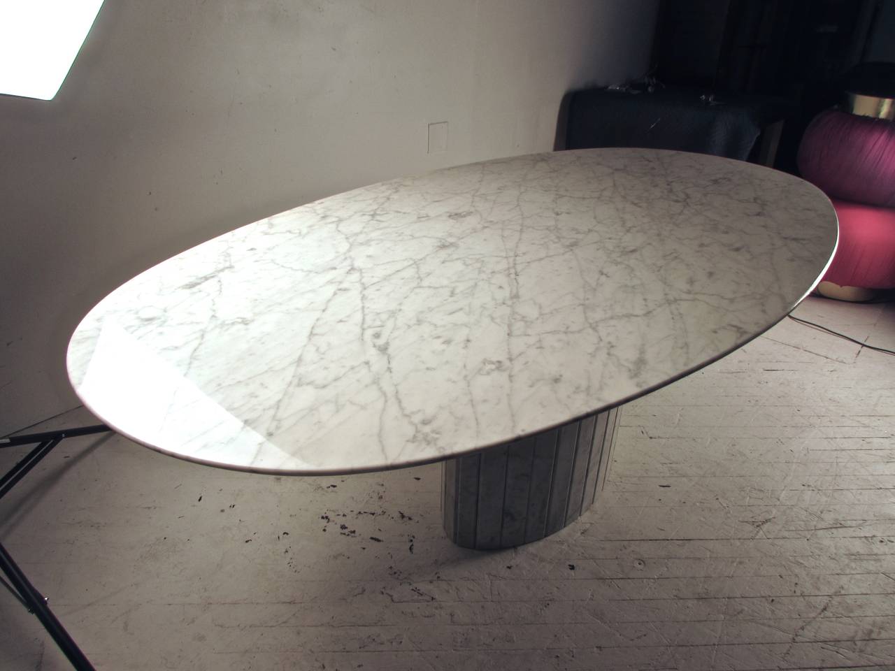 Gorgeous oval knife-edged Carrara marble dining table, Italy, circa 1970. The veins and markings in the marble top are dramatic and consistent throughout. The color is a true white with gray veins. Condition is immaculate with no cracks or chips.