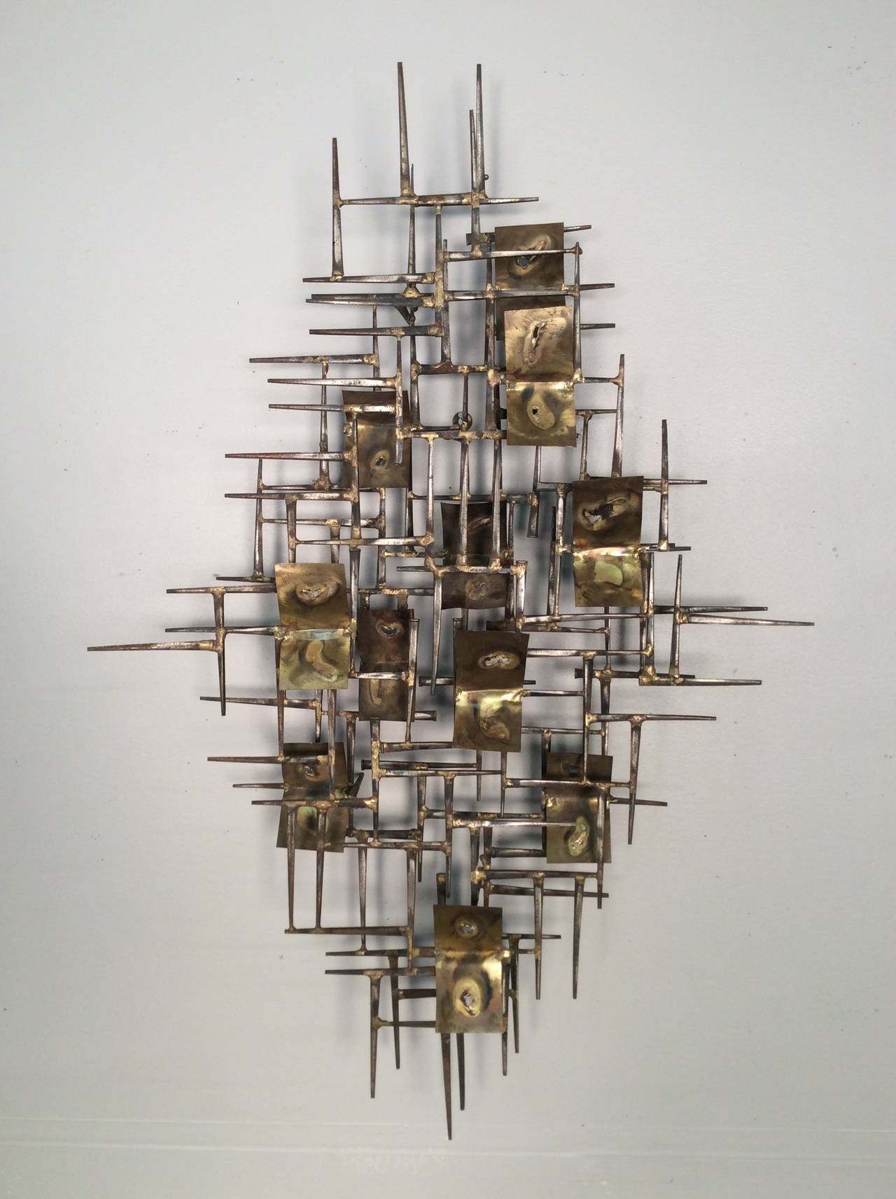 Brutalist nail and brass wall sculpture by William Bowie. This piece can be hung either vertically as pictured, or horizontally. Condition is excellent.