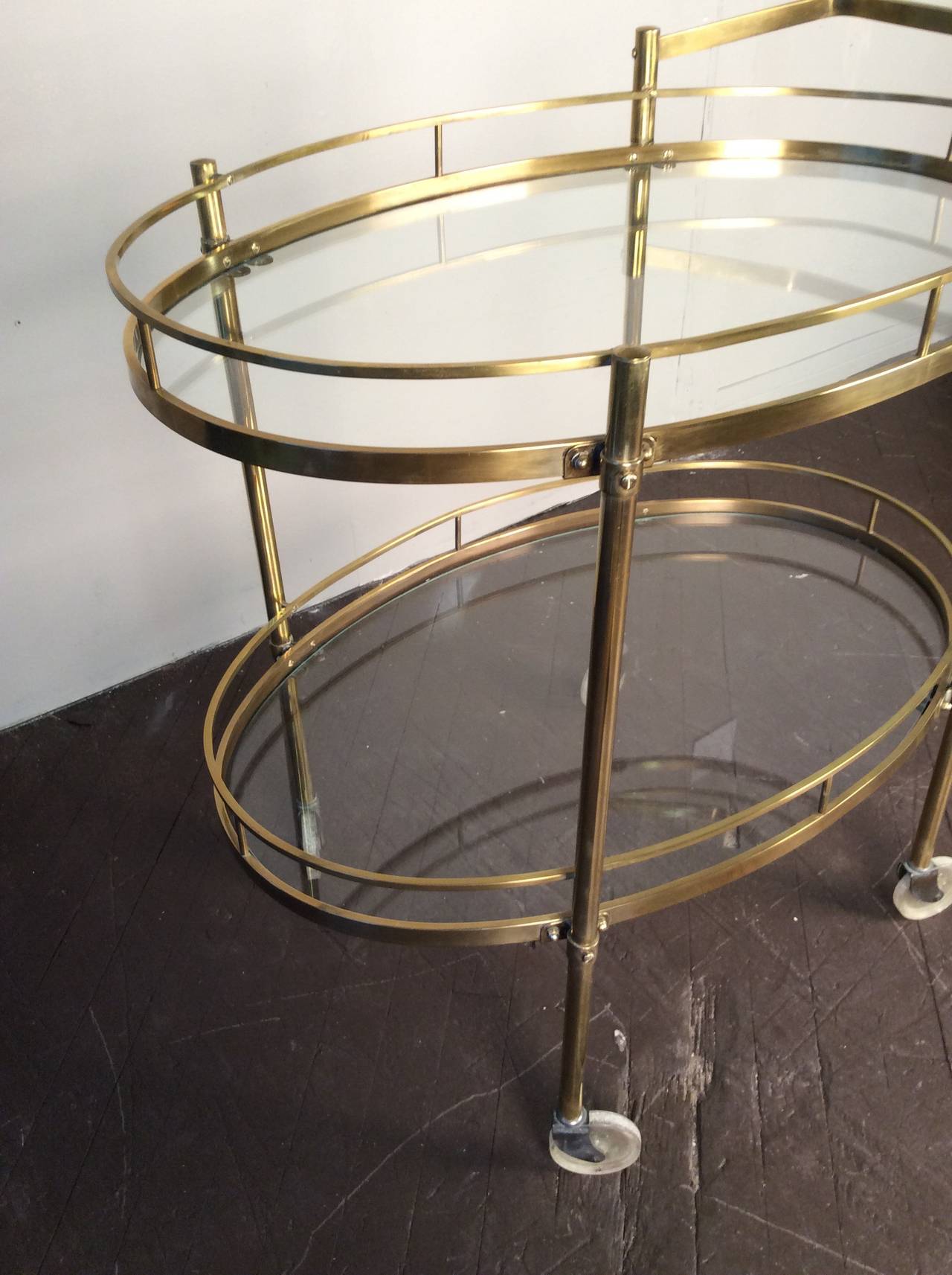 Beautifully patinated solid brass bar cart by Maxwell Phillips, NYC, circa 1960. This piece is in excellent condition. The brass is beautifully polished and warm in tone. Great addition for any cocktail party.