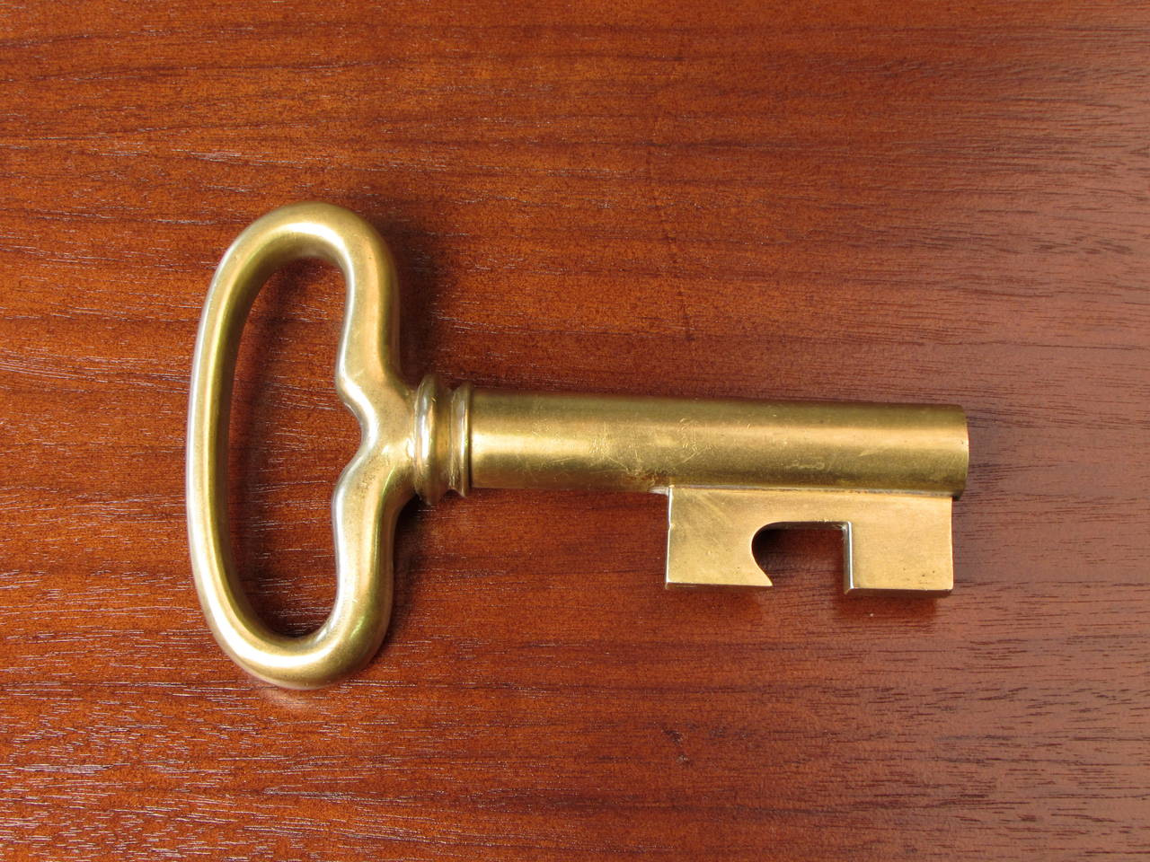 Large brass key bottle opener with hidden cork screw by Carl Auböck, 1950s. This piece is fantastic such a delight in person. You really appreciate the scale in person. Very large! Condition is excellent with normal age to brass. Stamped 