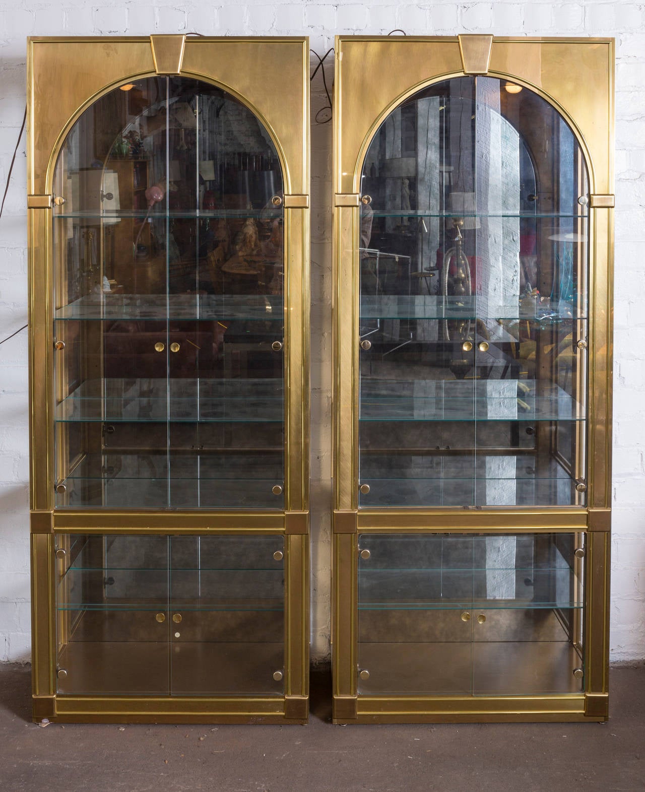 Gorgeous pair of solid brass display case vitrines by Mastercraft, circa 1970. This pair is in gorgeous vintage condition with normal wear. Brass has a beautiful patina. Each vitrine has six shelves.

Measures: 84.25