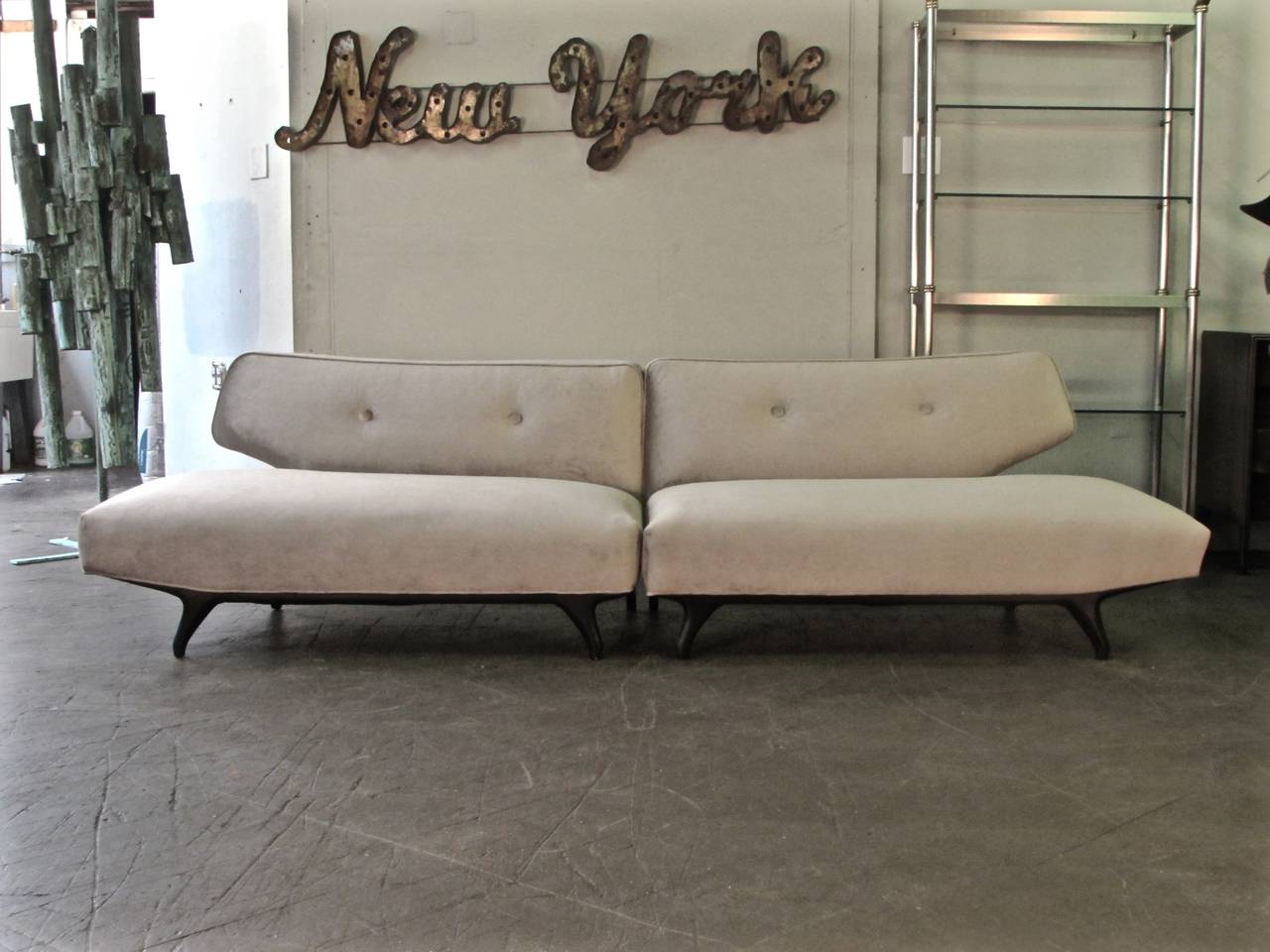 Seductive two-piece Italian sofa with sculptural ebonized legs, circa 1960. This sofa is absolutely stunning and unusual. Fantastic lines and with a sleek gondola shape, this sofa is a true centerpiece. We have upholstered it in a neutral gray