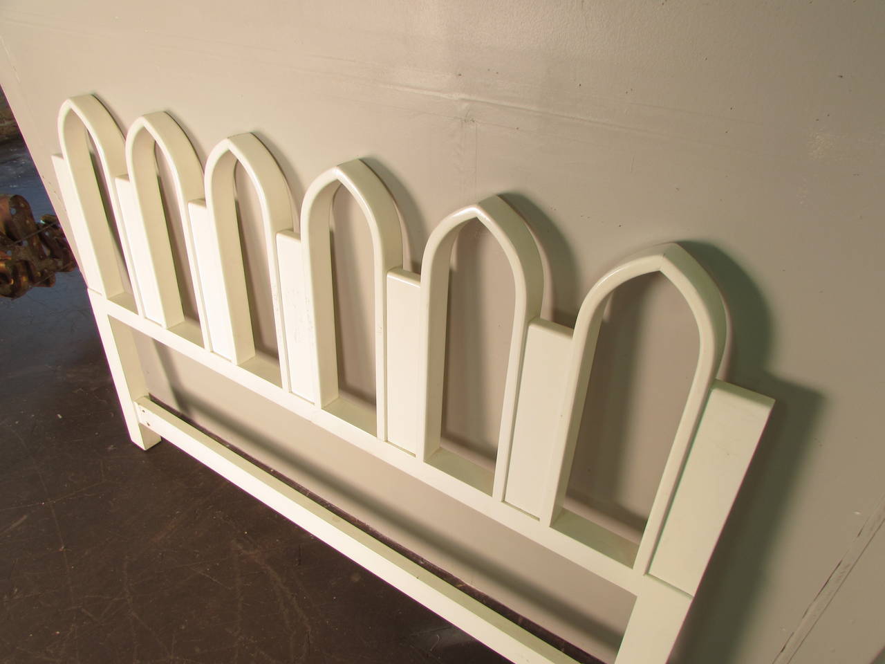 White lacquered headboard with Gothic arch detail by Harvey Probber, 1965. Headboard is wide enough for a 60" queen-sized mattress but was used for a full-sized mattress. Condition is excellent. 