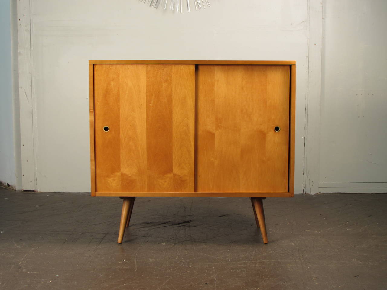 Paul McCobb sliding door cabinet with splayed legs. Newly refinished and excellent condition. Great piece for a small space. Could be used as a buffet, sideboard, credenza, bar, etc.

We offer free regular deliveries to NYC and Philadelphia area.