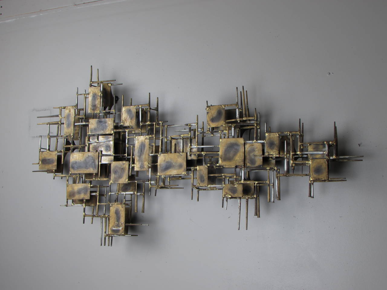 Large Brutalist wall sculpture in brass and steel by Marc Creates, signed 1960s. Can be hung vertically or horizontally as pictured. Abstract nail composition with with two layers giving it a three-dimensional appearance. Brass pieces and nails are