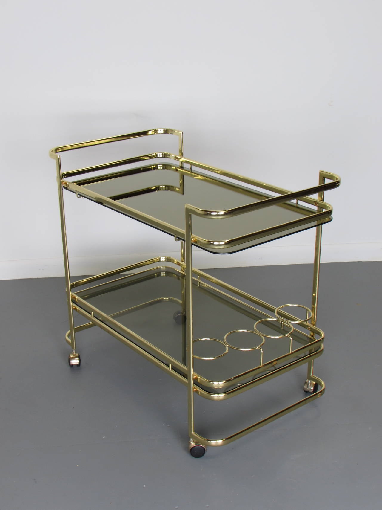 Beautiful brass bar cart with smoked glass, 1970s. Brass is in excellent condition with minor wear. Shows beautifully. 

We offer free regular deliveries to NYC and Philadelphia area. Delivery to DC, MD, CT and MA are available if schedule