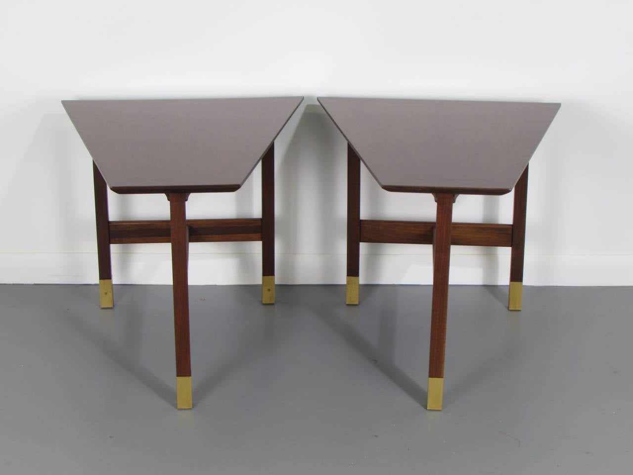 Handsome trapezoidal walnut and brass end tables by Harvey Probber, 1960s. These tables have been completely restored and are in excellent condition. 

See this item in our private NYC showroom! Refine Limited is located in the heart of Chelsea at