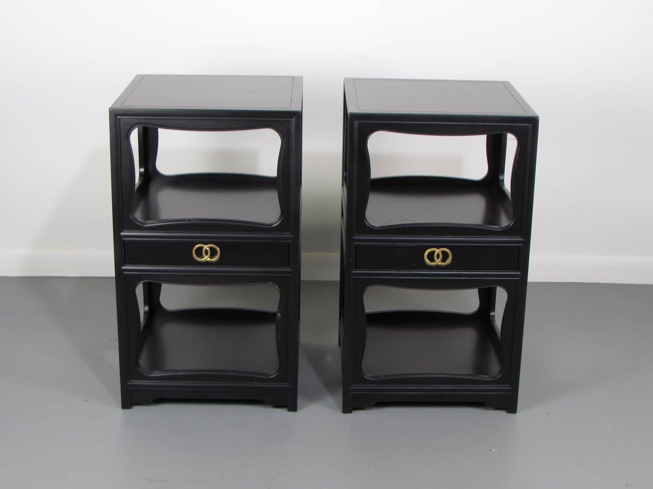 Pair of Hollywood Regency lacquered end tables or nightstands by Michael Taylor for Baker, 1950s. The gilded inset ring pulls in the center drawers are a signature of Michael Taylor's 