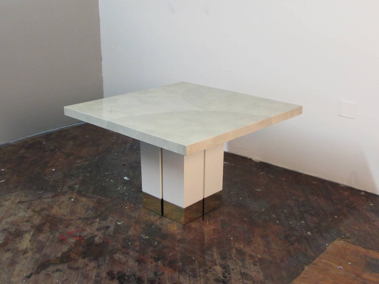 Handsome Italian goatskin or parchment dining table with brass details on white lacquered base in the manner of Karl Springer. This table is a perfect match for a small dining room or eat-in kitchen--seats 4 people. The quality and weight of the