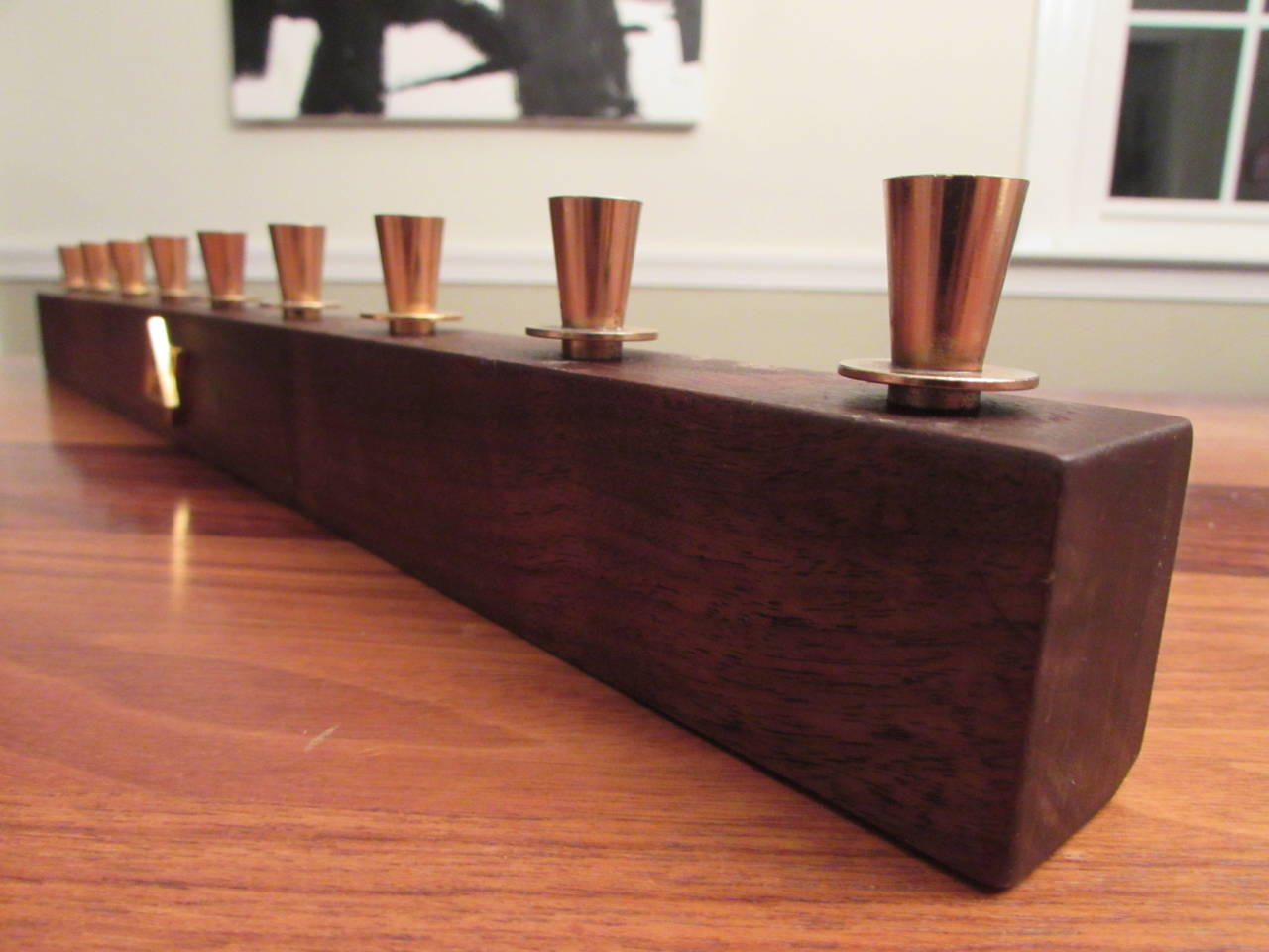 Black walnut and brass menorah designed by Paul Evans for Raymor in 1955 and produced until 1959. This design has been confirmed by Evans' studio assistant, Dorsey Reading, and is documented (see pics). There were five models in the series--this is