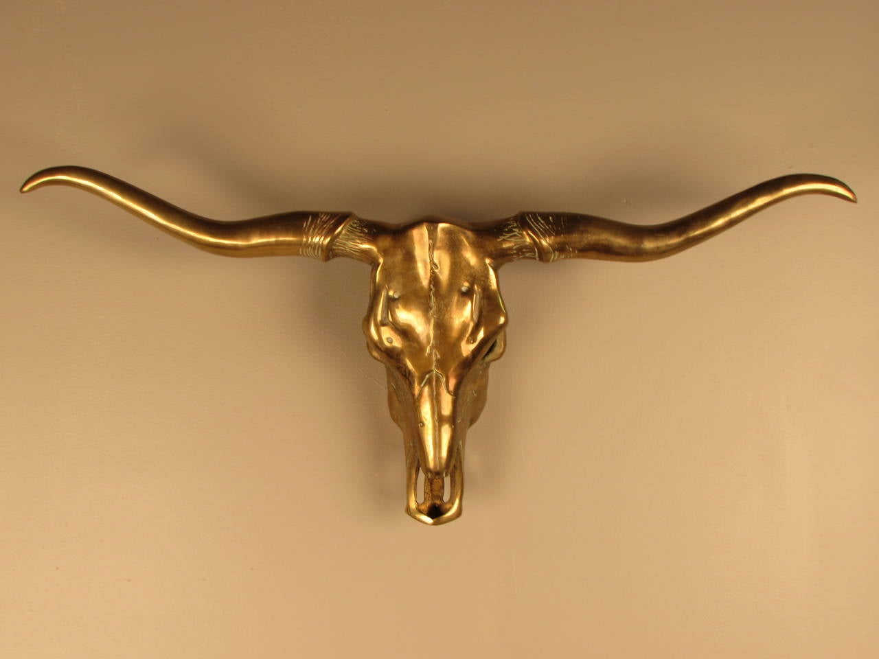 Striking cast brass longhorn steer skull and horns. Incredible decorator piece, glamorous and a bit wicked! Gorgeous golden patina. Substantial scale and weight. Size is that of a lifesize calf.
