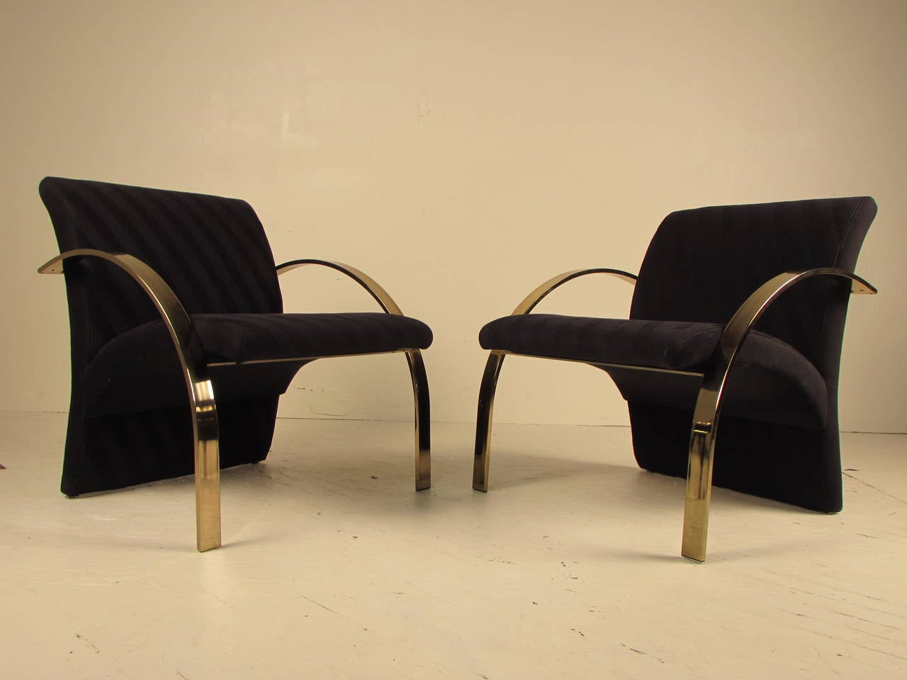 Stunning, highly sculptural brass armchairs or lounge chairs made by Directional. Fabric is a wool blend with a ruched diagonal stripe in a very, very dark midnight blue that reads black in some lighting.

Brass is in exceptional vintage condition