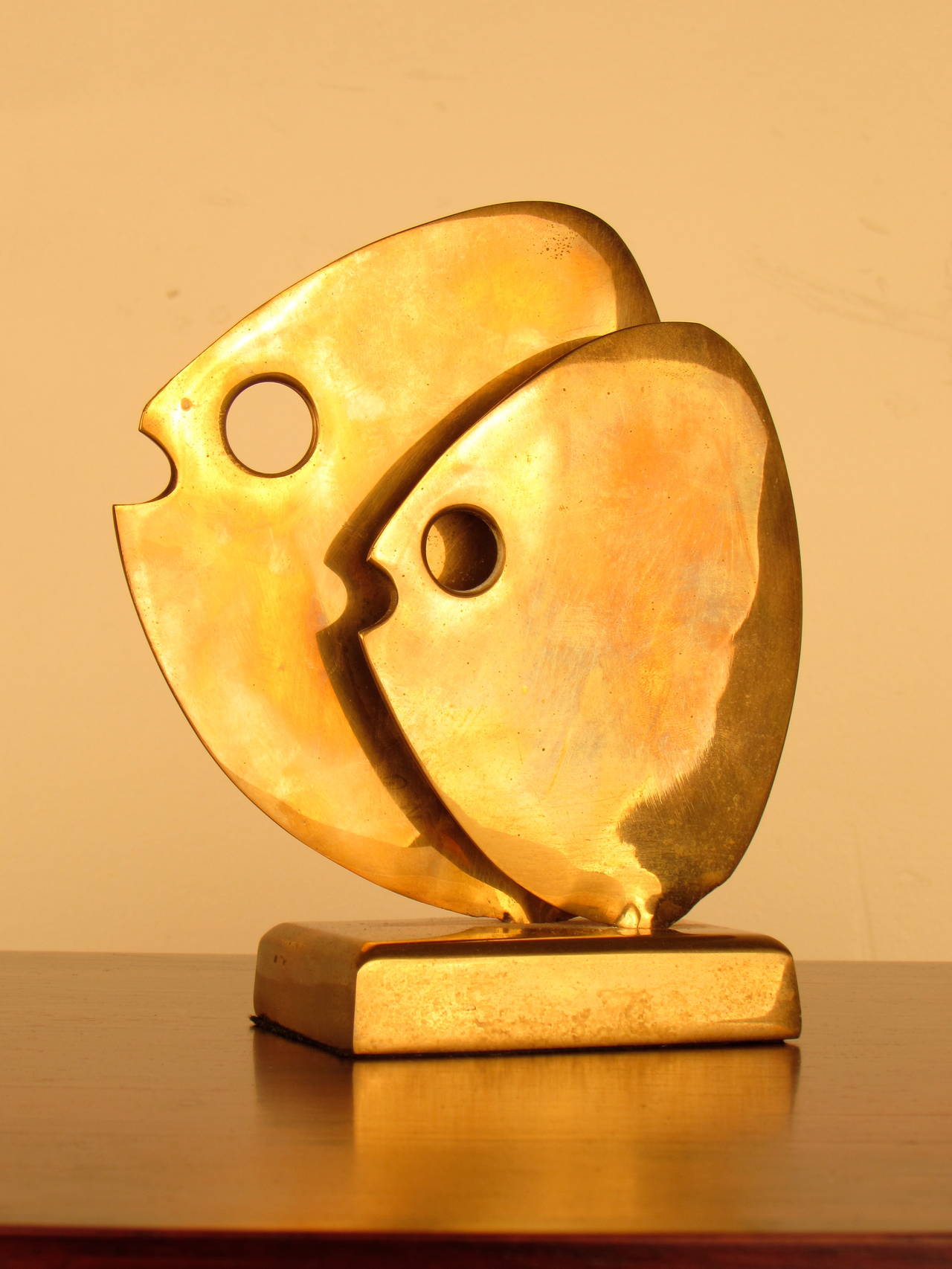 Radiant brass table sculpture of two stylized fish on rectangular base made by  Hattakitkosol Somchai (1934-2000), a Thai artist who specialized in metal sculpture.