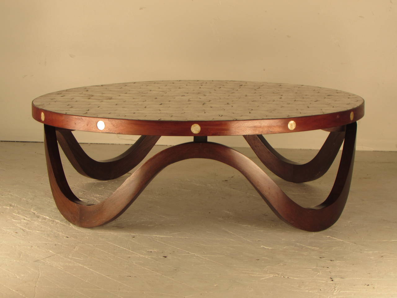 Absolutely marvelous 1940s cocktail table with sculptural, undulating walnut frame and radiant capiz shell top and inlays. Really an extraordinary piece, we've never seen another one like it!

Overall excellent condition with minor wear consistent
