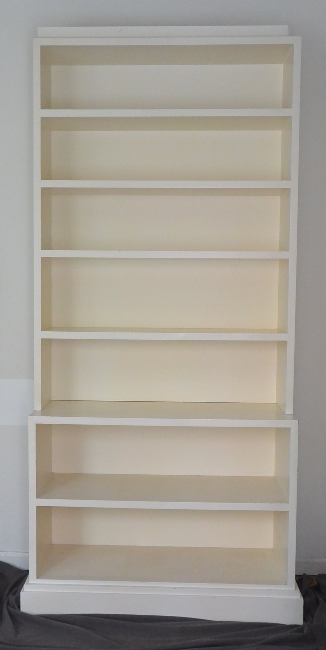 Pair of vintage modern white painted bookcases from the personal collection of Albert Hadley. Each bookcase is in two parts with separate crown. 
Dimension: 44
