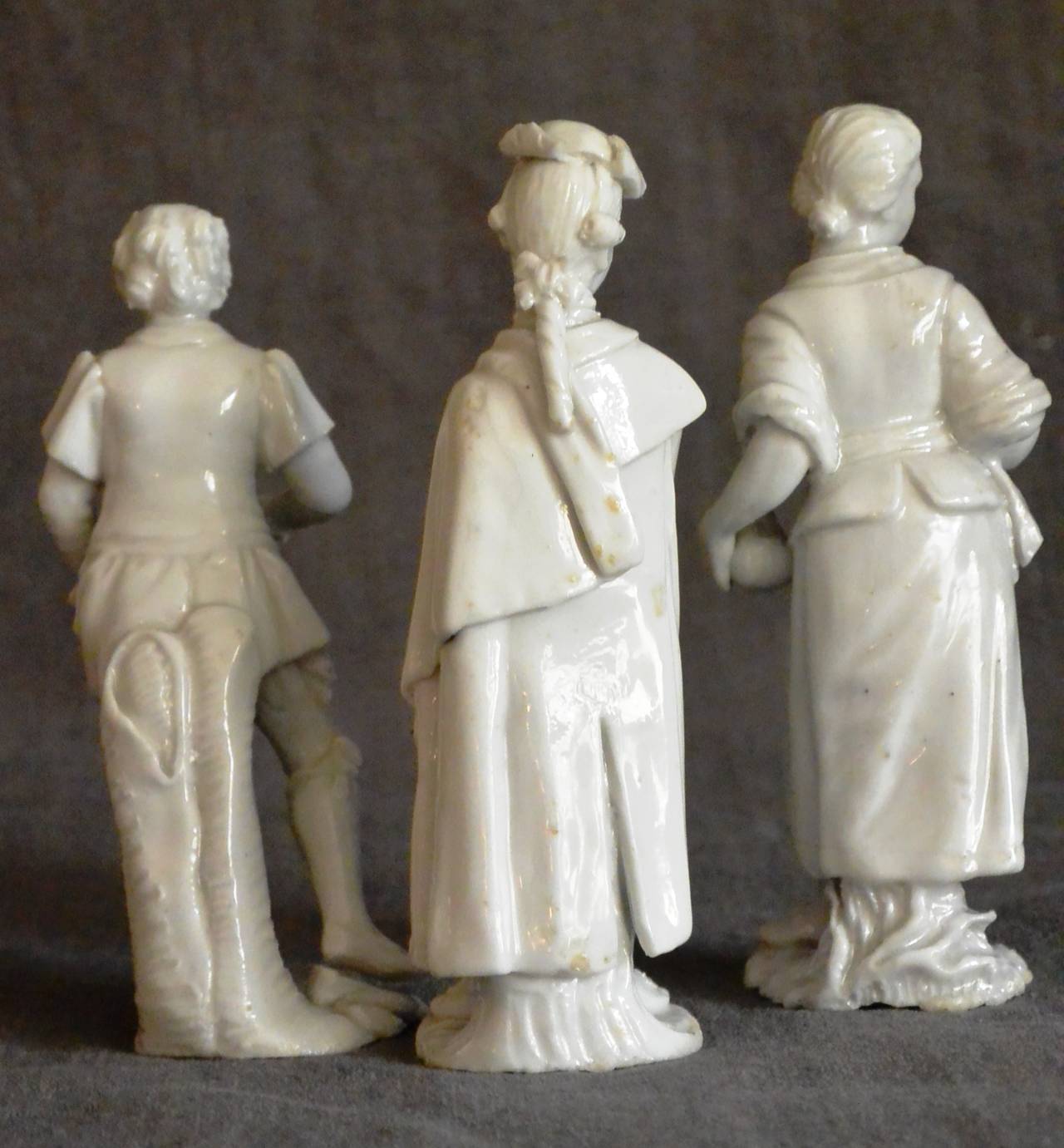 Set of three Cozzi white porcelain Venetian figures. Three small porcelain sculptures in the signature Cozzi glazed paste of a nobleman clutching a flower, a woman holding a carafe, and a young boy holding flowers, Italy, circa