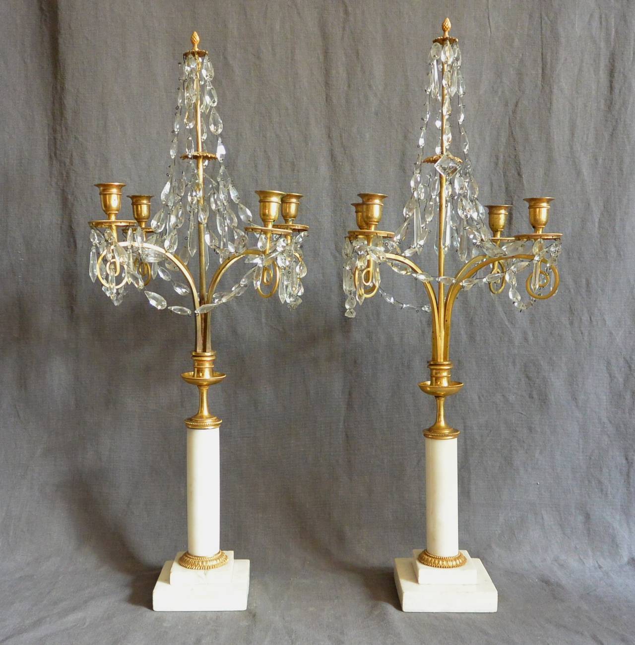 Pair of Continental crystal and marble candelabra. Ormolu, crystal and white marble four-arm candelabra with delicate crystal drops suspended from pierced bobeche. Possibly Swedish or Russian, circa 1820.
Dimension:
Candelabra 1: 4.5