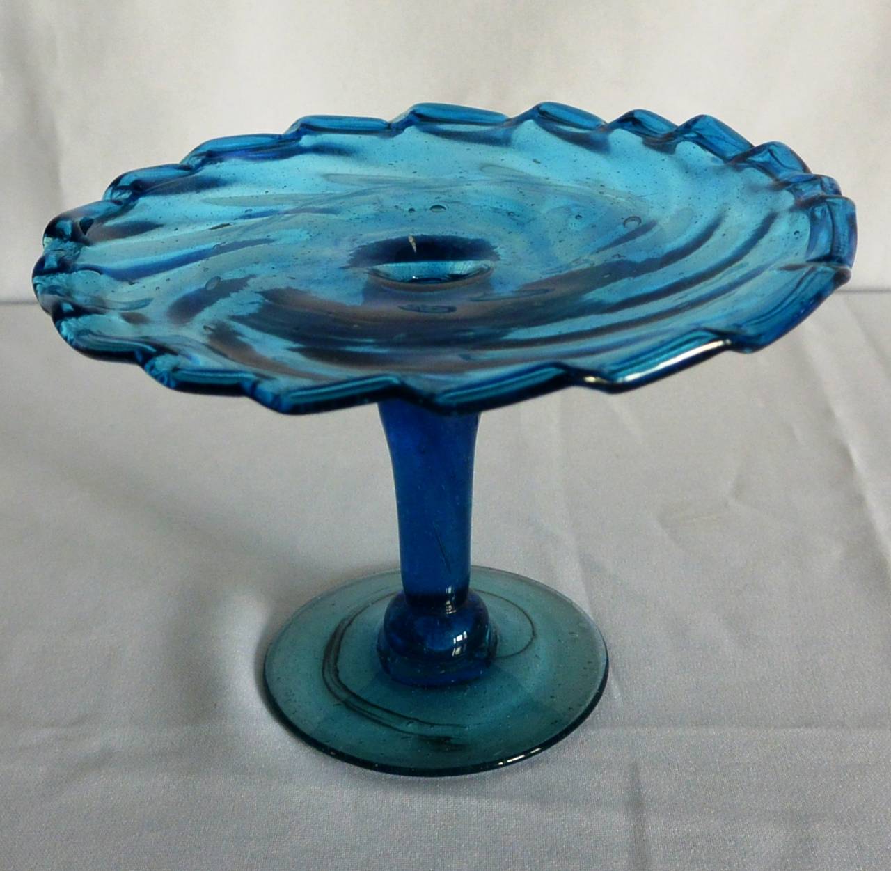 Blue Murano Glass Cake Stand. Hand-blown Venetian rope twist border glass cupcake/petits-four stand. Italy, early 20th Century.
Dimension: 7.5