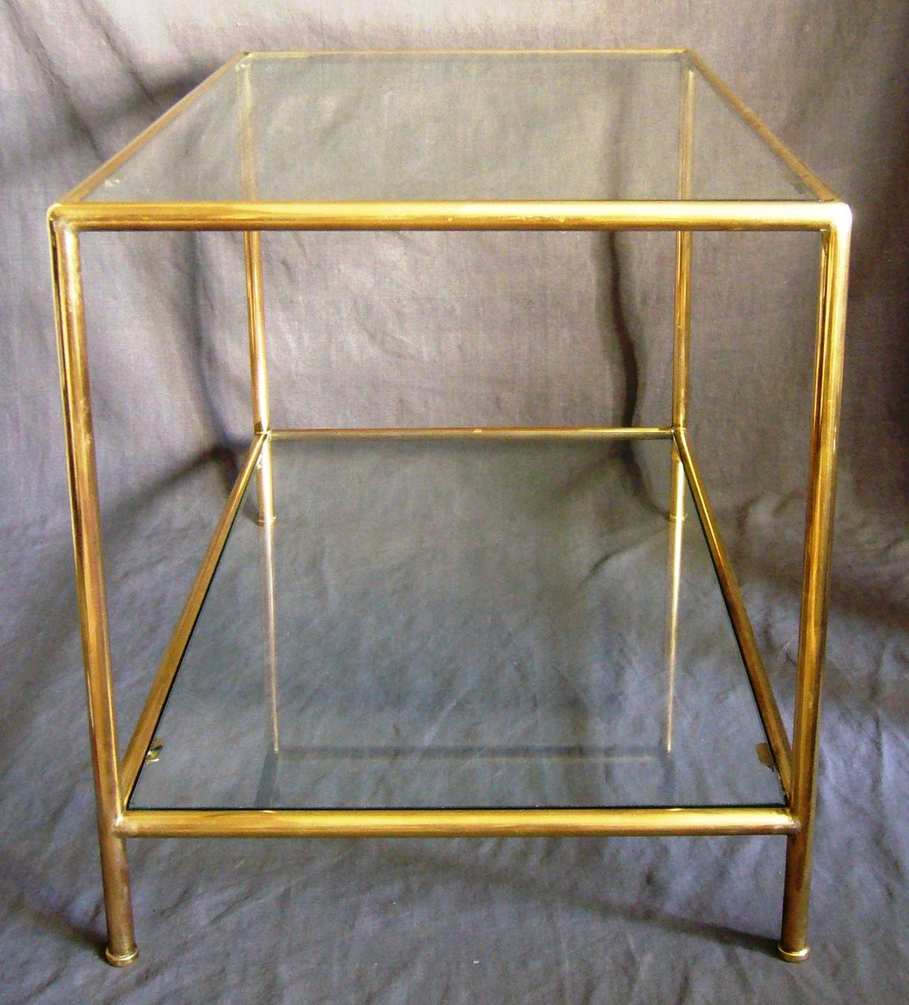 Italian seamless tubular brass coffee table.  Mid-Century Modern seamless tubular brass two-tier coffee table with two glass shelves on elegant capped feet, Italy, circa 1940.
Dimension: 32