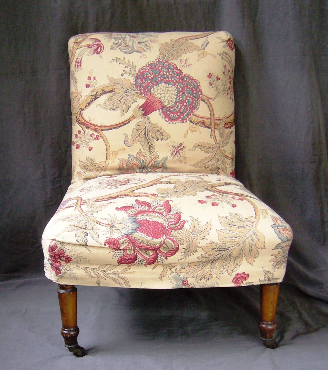Antique slipper chair upholstered in cream file with Bennison linen and velvet slipcover on turned wood legs with casters. England, circa 1870. 
Dimension: 24
