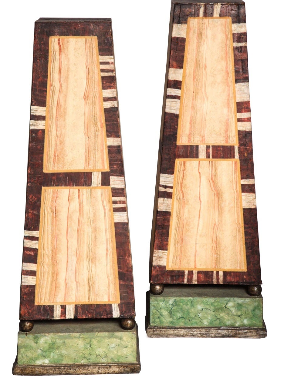 Pareja de grandes pedestales obelisco de mármol de imitación del Renacimiento egipcio.  Pedestales pintados muy decorativos en forma de obelisco con tres tipos de piedra sobre pies de bola plateados que descansan sobre plataformas elevadas.  Italia,