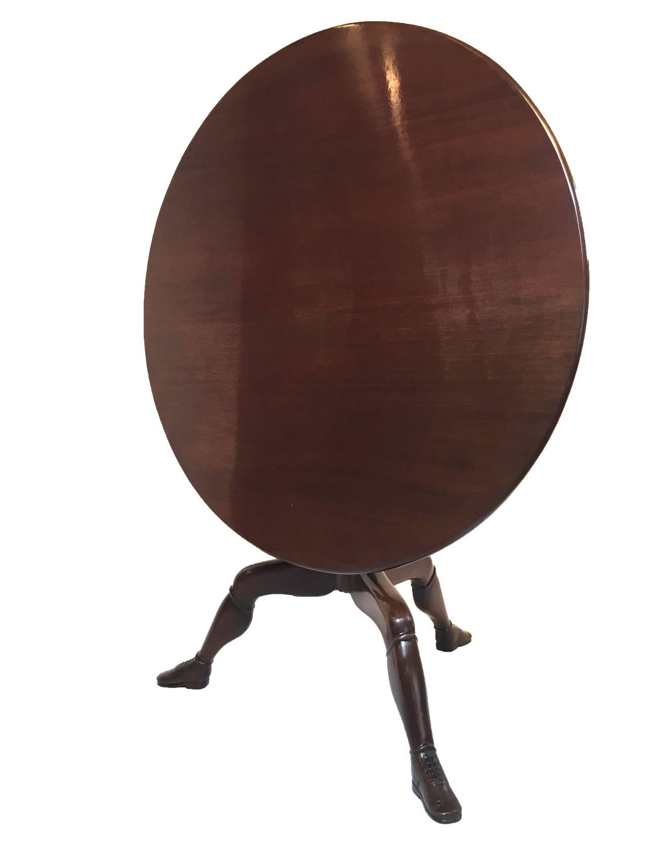 20Th Century mahogany center table with a flip top, bird cage base, and  cabriole legs featuring unusual child's calf and wingtip shoe Isle of Man motif for the feet. Recent refinishing using beautiful French Polish method. Original brass latch.